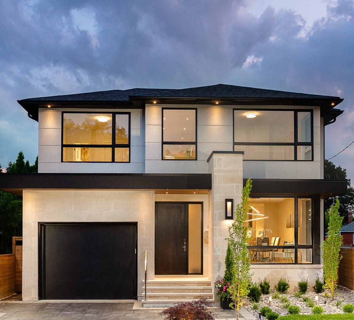 A large modern home with black garage door.